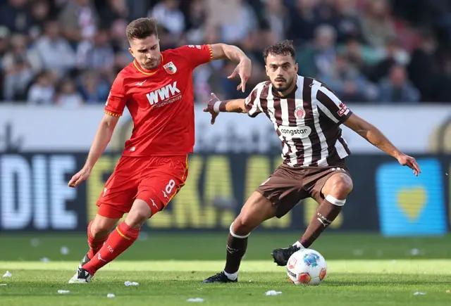 Elvis Rexhbecaj of Augsburg challenges Danel Sinani (right) of FC St.Pauli