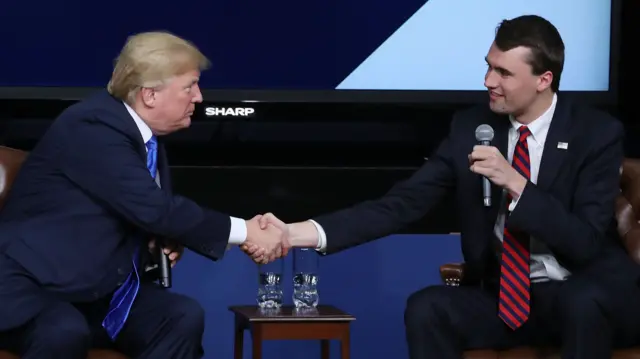 .S. President Donald Trump shakes hands with conservative activist Charlie Kirk at a forum dubbed the Generation Next Summit at the White House on March 22, 2018