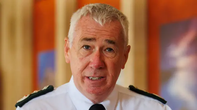 Jon Boutcher speaking inside, he has short white hair and is wearing a PSNI uniform.