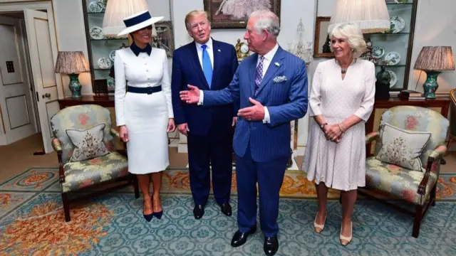 Donald and Melania Trump stand next to King Charles, who is speaking to the group, and Queen Camilla