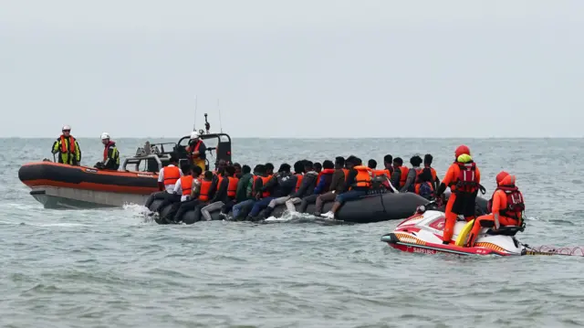 Migrants in a small boat are intercepted by French authorities