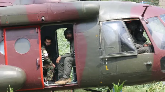 Men look out of a helicopter door