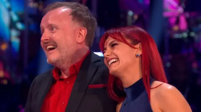 Chris and Diane laugh together. Diane leans towards Chris' shoulders