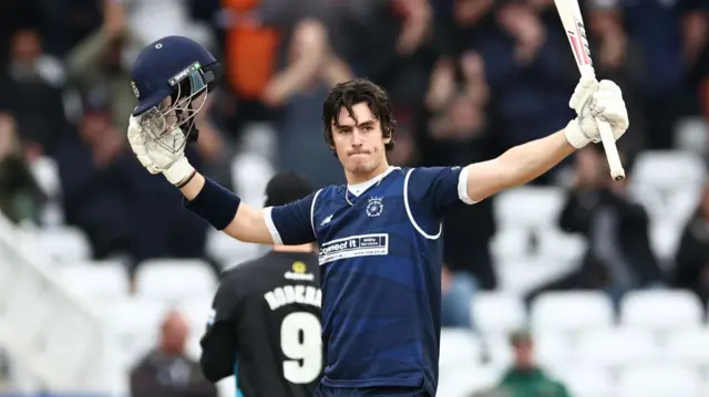 Ali Orr raises his helmet and bat after reaching his century