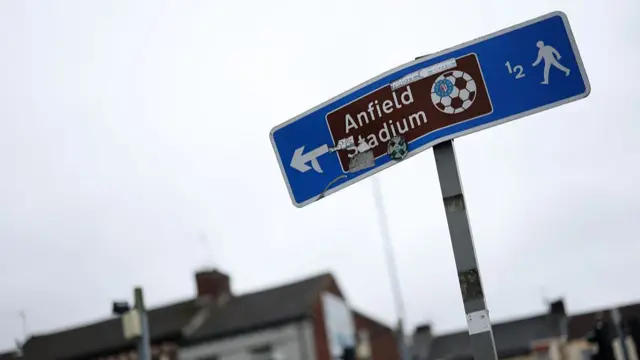 A street sign shows the direction to Anfield Stadium