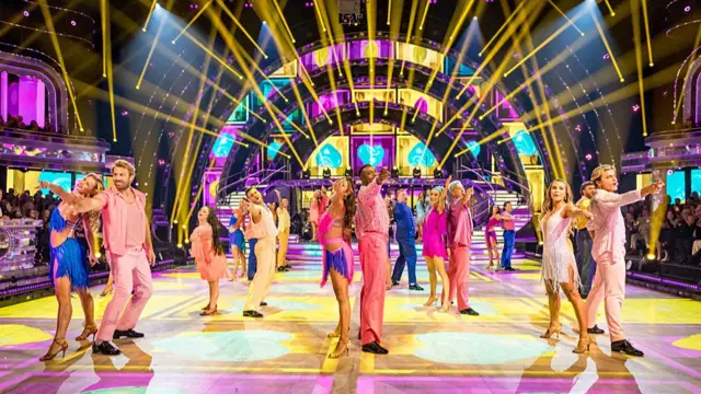 All the celebrities and their partners pointing towards the camera on the dance floor