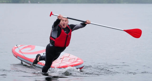 Liberal Democrat Leader Sir Ed Davey falls into the water while paddleboarding on Lake Windermere
