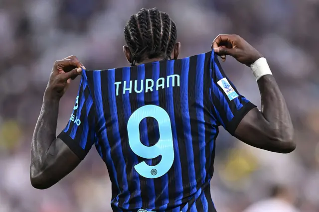 Marcus Thuram holding up the name on the back of his shirt
