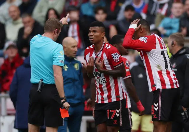Reinildo speaks to the referee after being sent off