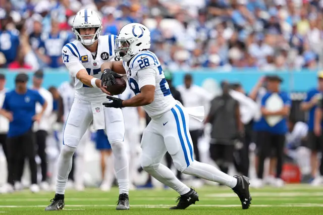 Daniel Jones hands the ball to Indianapolis Colts team-mate Jonathan Taylor