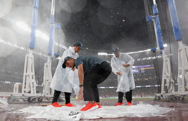 Staff putting towels over discus throwing area