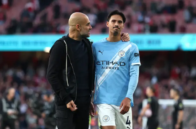 Manchester City manager Pep Guardiola and Tijjani Reijnders speak after the match