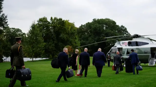 White House staff members walk toward Marine One