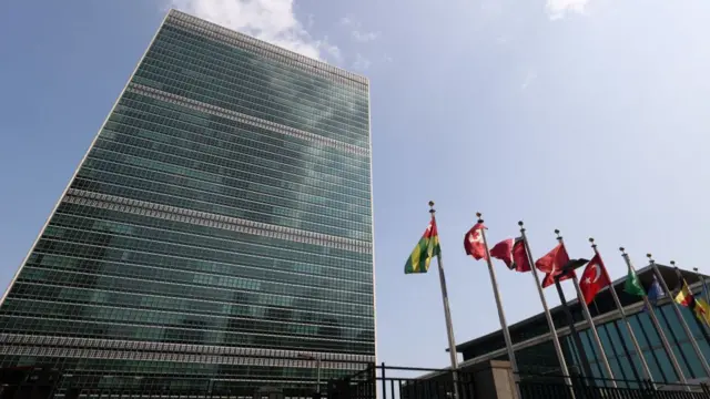 A view of the UN building in Manhattan, New York with several national flags flying outside it