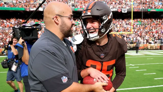 Cleveland Browns kicker Andre Szmyt celebrates with a staff member after his game-winning field goal against the Green Bay Packers