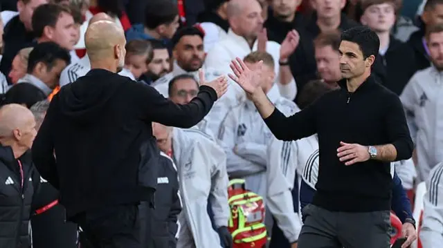 Pep Guardiola high fives Mikel Arteta