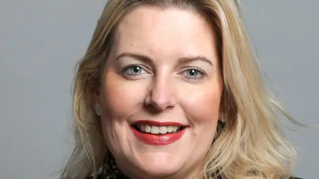 Mims Davies, a middle-aged blonde woman, smiles into the camera.