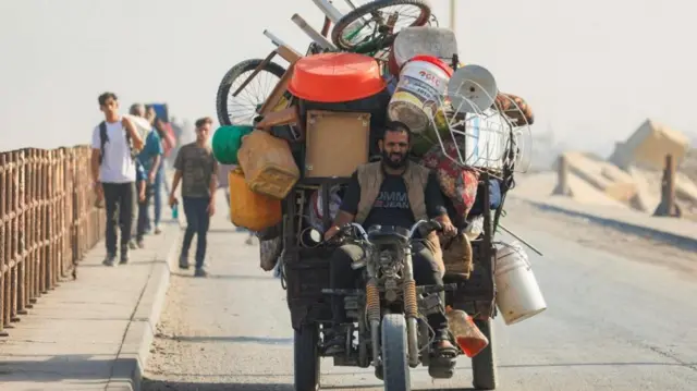 A displaced Palestinian, fleeing northern Gaza due to an Israeli military operation, moves southward after Israeli forces ordered residents of Gaza City to evacuate to the south, in the central Gaza Strip, September 22, 2025.