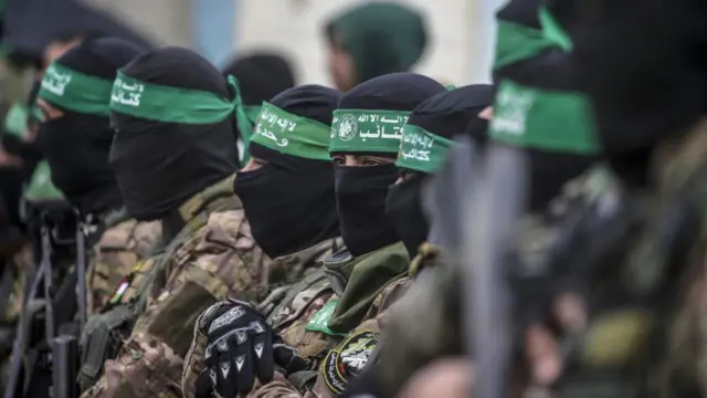 Fighters from Hamas wearing combat fatigues and black balaclavas seen in a file photo from February 2025