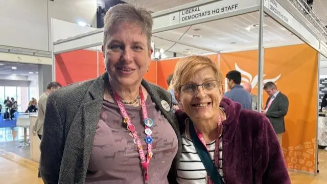Imogen and Rachelle Shepherd stand at a conference hall at the Lib Dem party conference in Bournemouth.