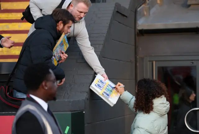 Cucurella signs an autograph for a fan
