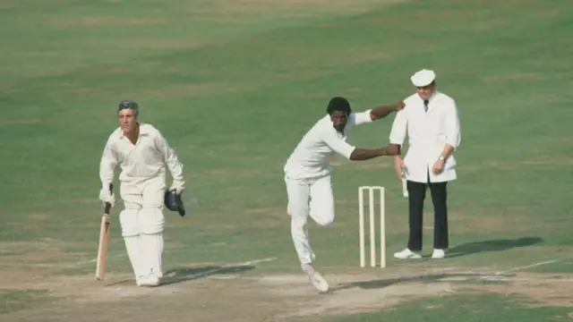Fast bowler Sylvester Clarke of Surrey County Cricket Club bowls to Paul Downton of Middlesex County Cricket Club as Middlesex Captain Mike Brearley and Umpire Dickie Bird look on