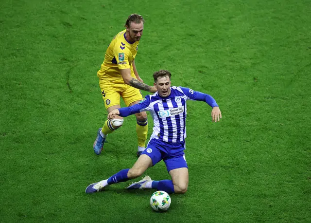 Wigan player falls to the floor under contact
