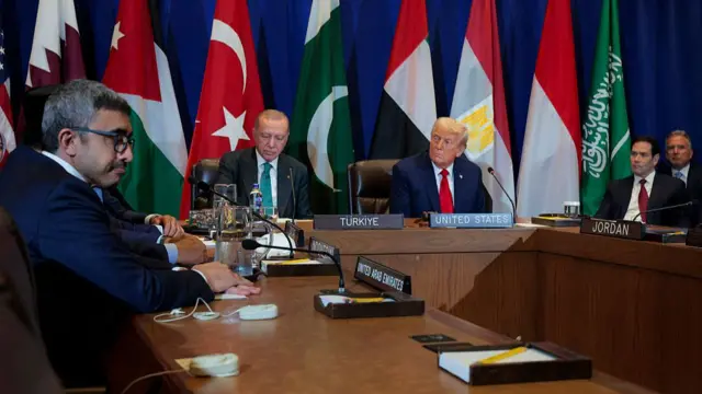 Erdogan and Trump sit side by side during a meeting with the leaders of several Arab and Muslim-majority states, with the flags of the attending countries behind them