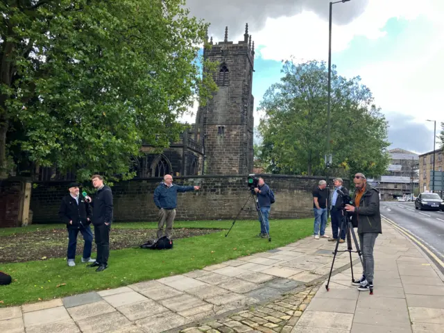 Members of the media assemble at the statue of Dickie Bird in Barnsley