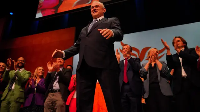Delegates applaud Ed Davey as he speaks on stage
