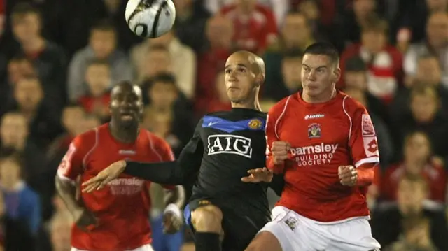 Adam Hammill challenges Gabriel Obertan for the ball during Barnsley's EFL Cup tie with Manchester United in 2009-10