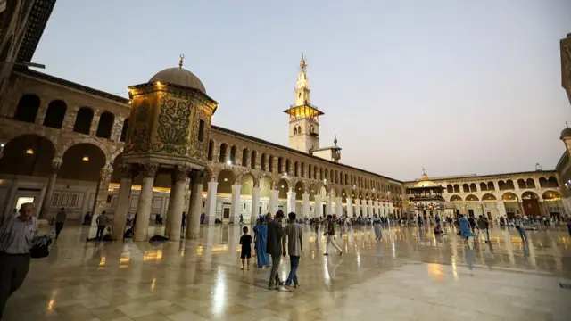 People walk in the Great Umayyad Mosque, known in short as the Umayyad Mosque, is seen on September 17, 2025 in Damascus, Syria.