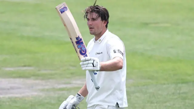 James Coles raises his bat in celebration