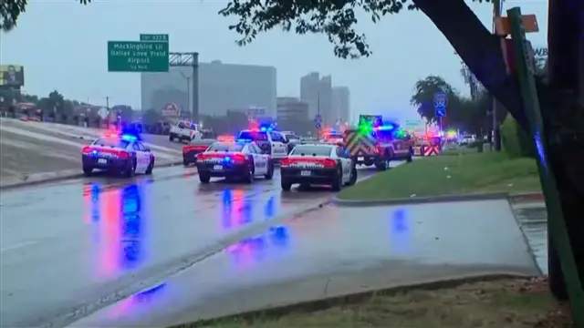 10 or more police cars with lights flashing on rainy street
