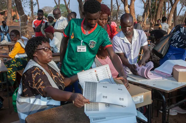 Malawi Electoral Commission (MEC) officials hold voting documents at the end of polling for the presidential and parliamentary elections, in Lilongwe on September 16, 2025