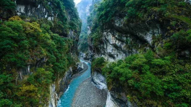A blue water river runs through a rocky valley in Hualien Taiwan