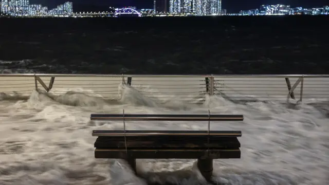 Waves from Super Typhoon Ragasa crash onto chair by the shore in Hong Kong