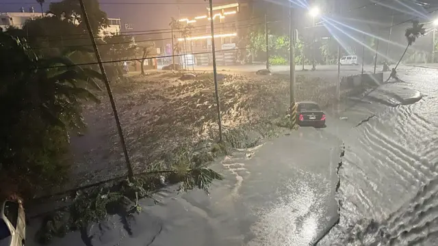 Stranded cars are seen as mud covers a neighbourhood after water from a burst landslide dam flooded the area in Hualien on September 23, 2025, as a result of heavy rain due to Super Typhoon Ragasa.