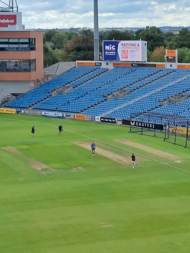 A shot of Ben Stokes bowling on the Headingley outfield as England team-mate Brydon Carse watches on