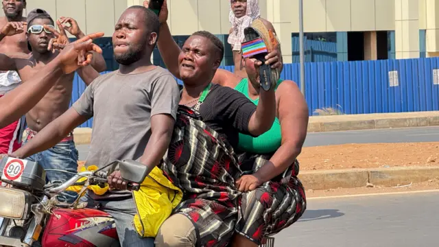 Three people travel on a motorbike amid the celebrations