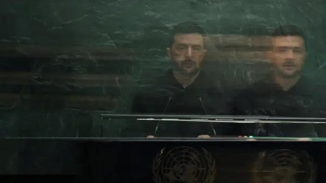 Zelensky's reflection in the green marble of the UN building