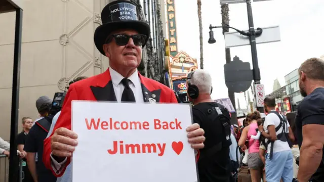 Gregg Donavan holds a sign outside the theatre where "Jimmy Kimmel Live!" was recorded for broadcast which says "Welcome back Jimmy"