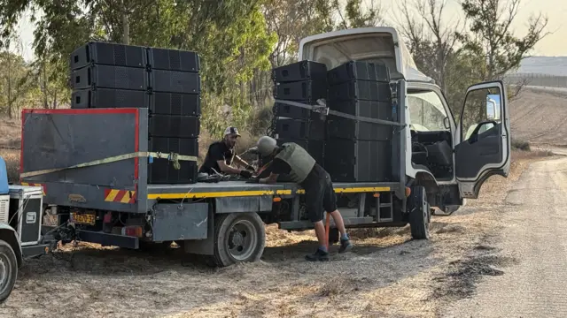 A man secures speakers to a truck on the Gaza border
