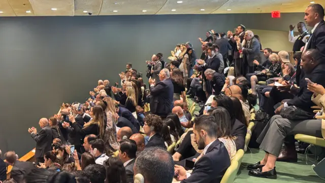 Some observers in the gallery above the GA hall stand and applause as Netanyahu walks off stage