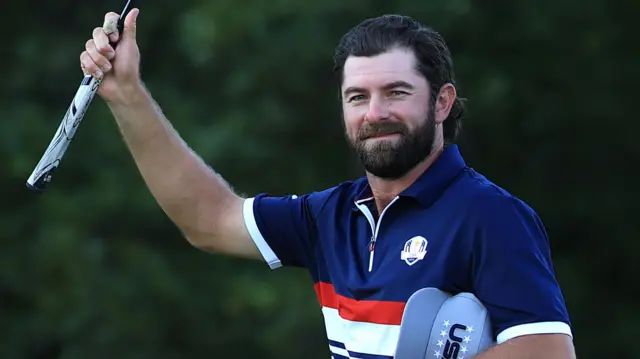Cameron Young raises his putter in triumph