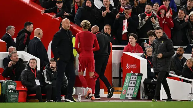 Hugo Ekitike walks past Arne Slot after being sent off