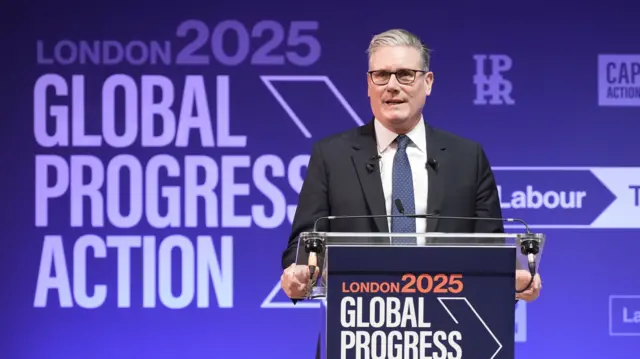 Kier Starmer stands at a podium delivering his speech. The purple background reads 'London 2025 Global Progress Action'