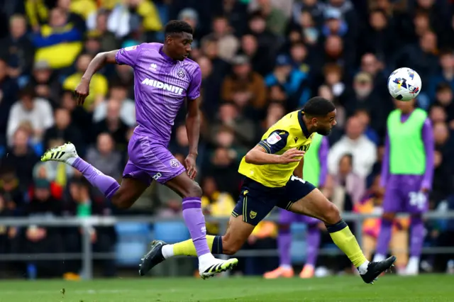 Brodie Spencer of Oxford United heads the ball clear whilst under pressure from Djibril Soumare of Sheffield United