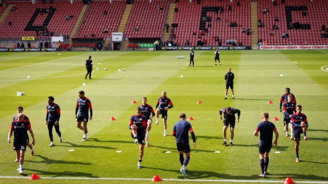 Stevenage players warming up on the pitch