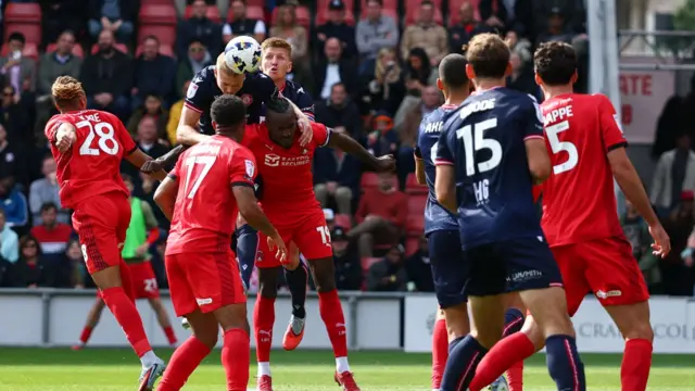 Lewis Freestone (second left) jumps and heads the ball